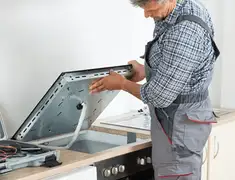 Appliance repair technician installing a built-in cooktop in Dover, DE