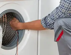 Dryer repair technician diagnosing and servicing a clothes dryer in Dover, DE