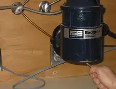 Garbage disposal repair technician tightening the mounting ring under a sink in Dover, DE