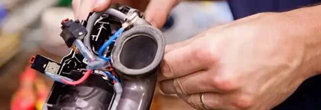 Vacuum repair technician reconnecting wiring and components in Dover, DE