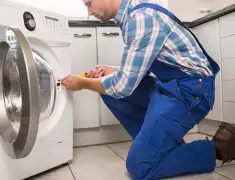 Washing machine repair technician servicing a front-load washer in Dover, DE