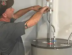 Water heater repair technician tightening supply line connections in Dover, DE